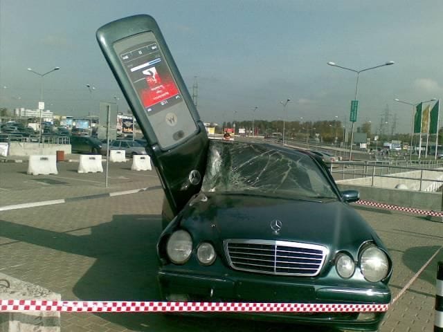 Móvil gigante destrozando un coche.